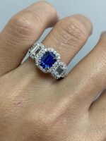 Iris-Emerald Cut Sapphire and Diamond Three Stone Halo Ring